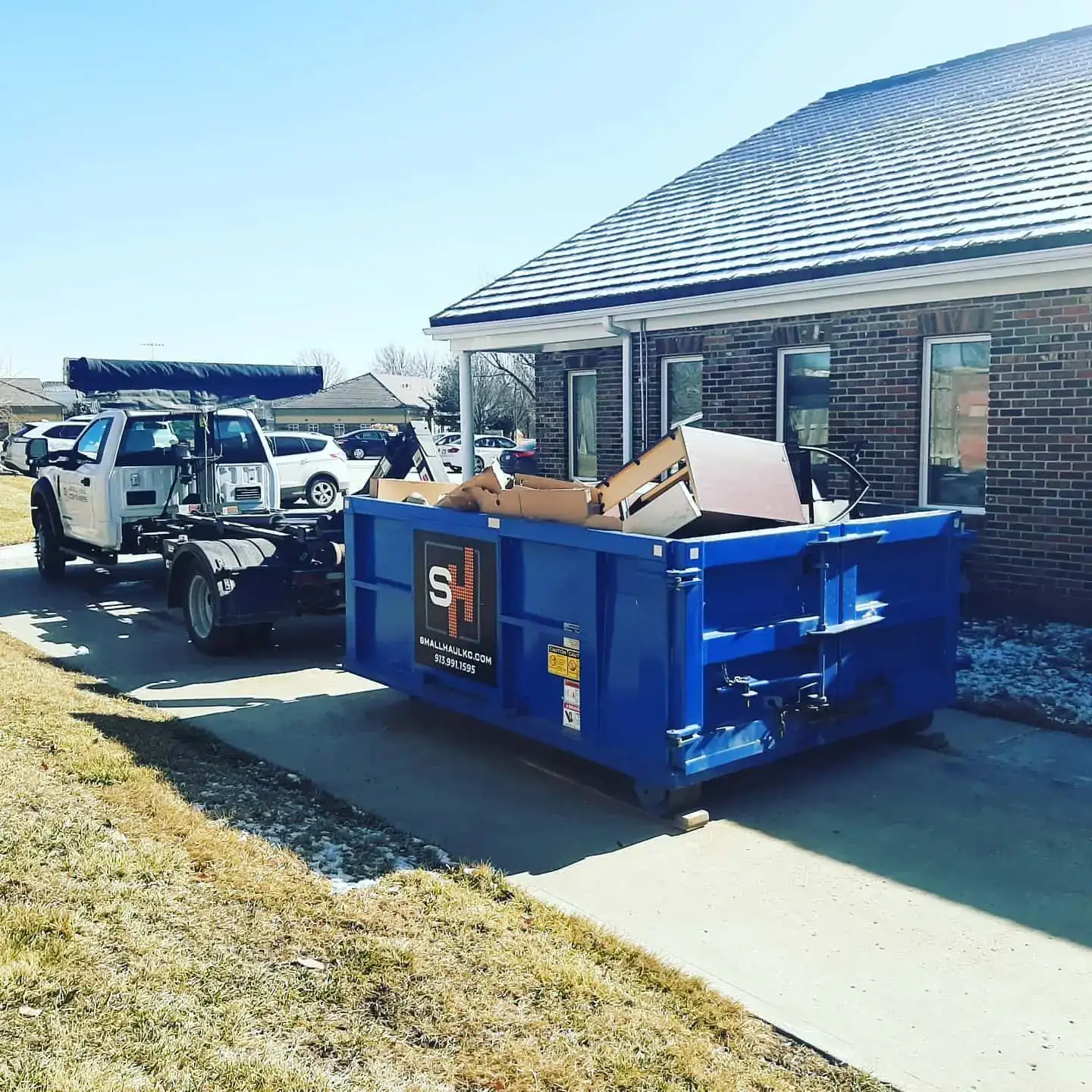 Small Haul Containers truck delivering a branded dumpster to a Johnson County home