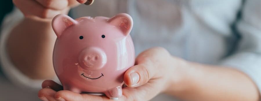 a coin is deposited into a smiling piggy bank